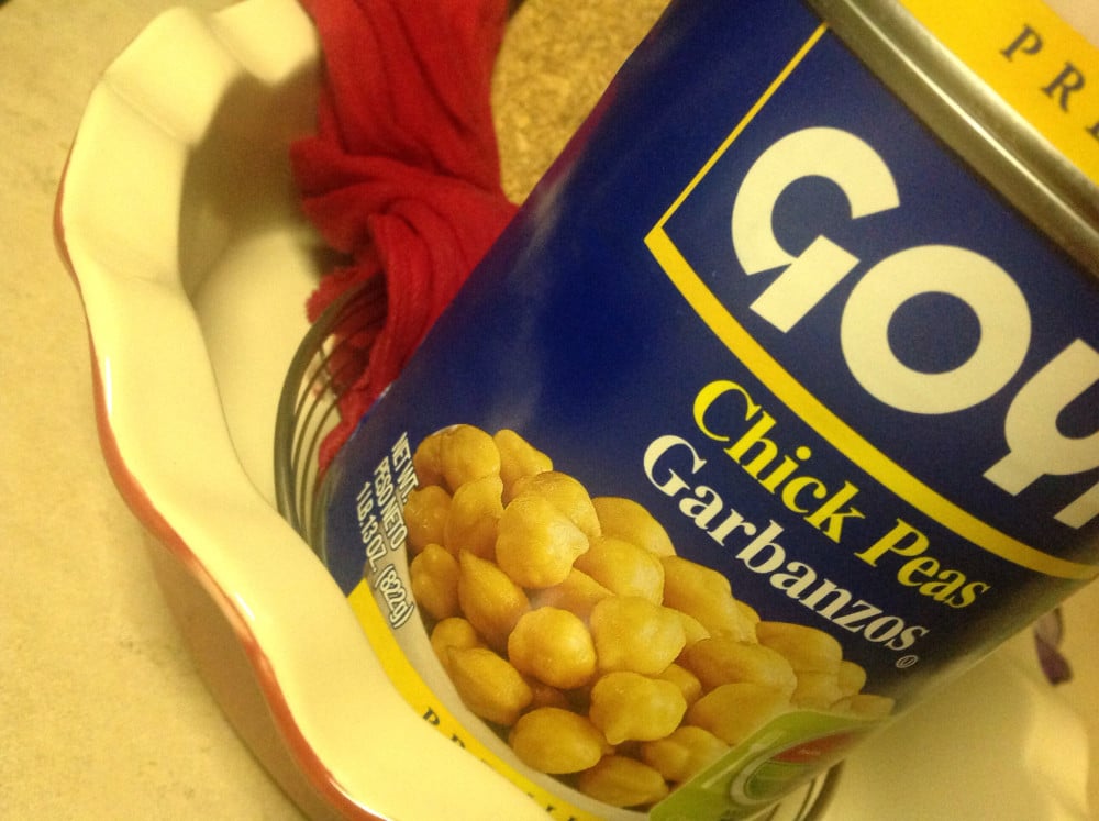 A can of chick peas weighing down the cheese cloth with paneer