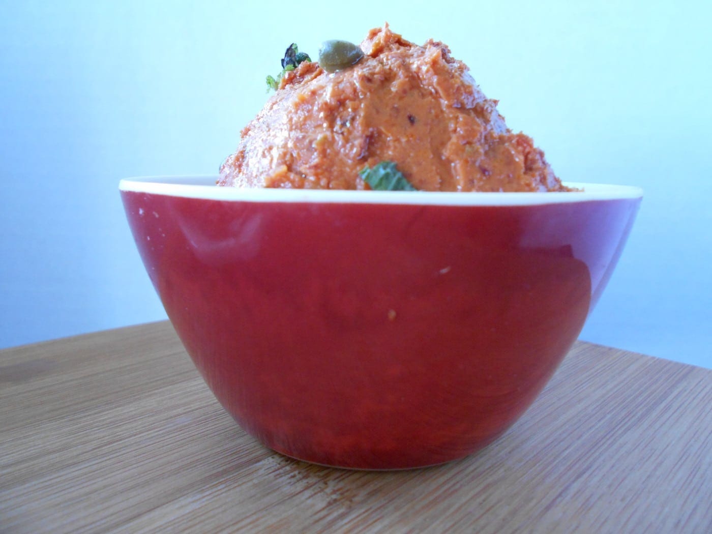 Front view of sun-dried tomaotes spread in a red bowl