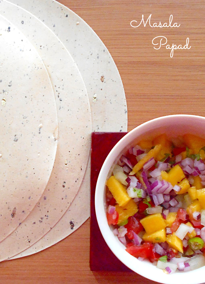 3 Dry Papads next to a White Bowl Filled With the Masala Papad Ingredients. 