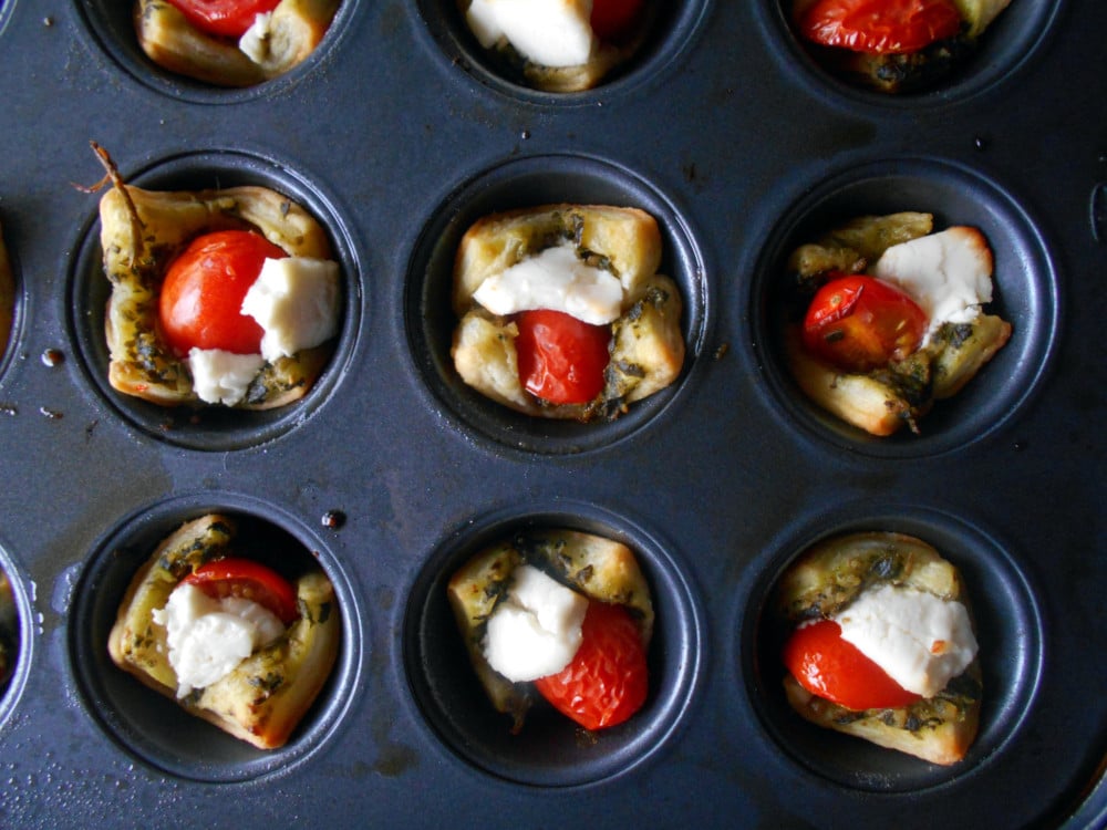 Caprese Salad Bites in a Puff Pastry Cup. Perfect bite-sized appetizers for any occasion. The Pesto acts as a base. Top with a balsamic vinaigrette reduction sauce. Quick and easy recipe
