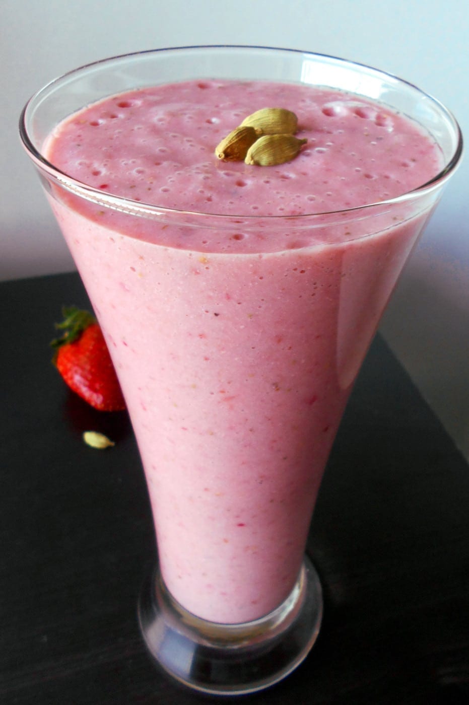 Front view of a tall glass filled with tomatillo strawberry smoothie