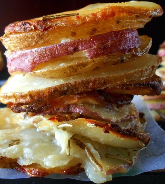 Front and closeup view of cooked russet, red potatoes and idaho potato slices stacked on top of each other.