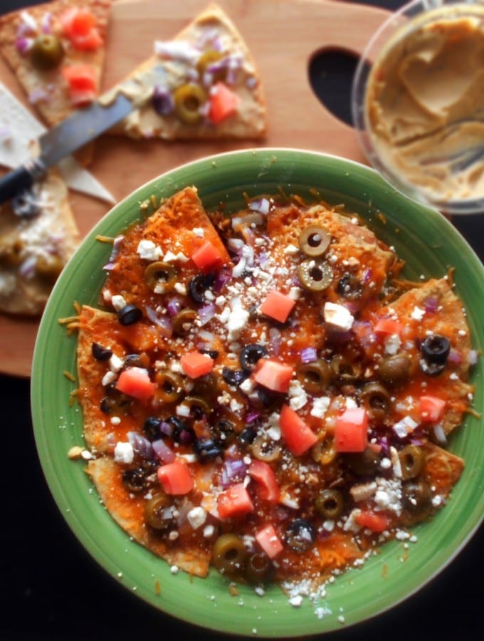 Greek Nachos Recipe made with Hummus, olives, tomatoes, feta and cheddar cheese. Mediterranean Diet Recipe