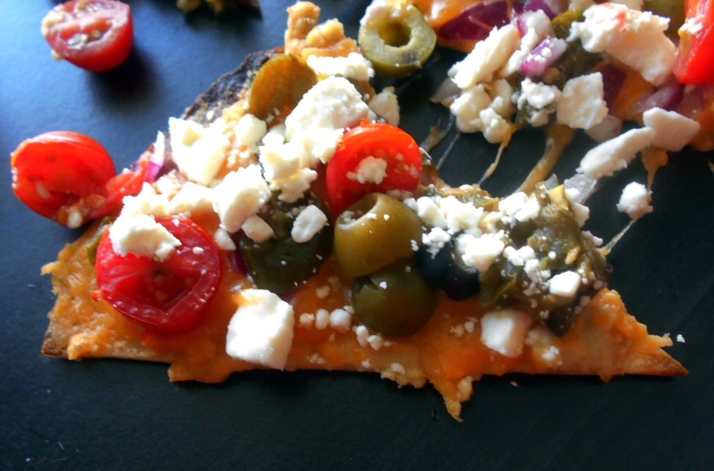 Greek Nachos Recipe made with Hummus, olives, tomatoes, feta and cheddar cheese. Mediterranean Diet Recipe