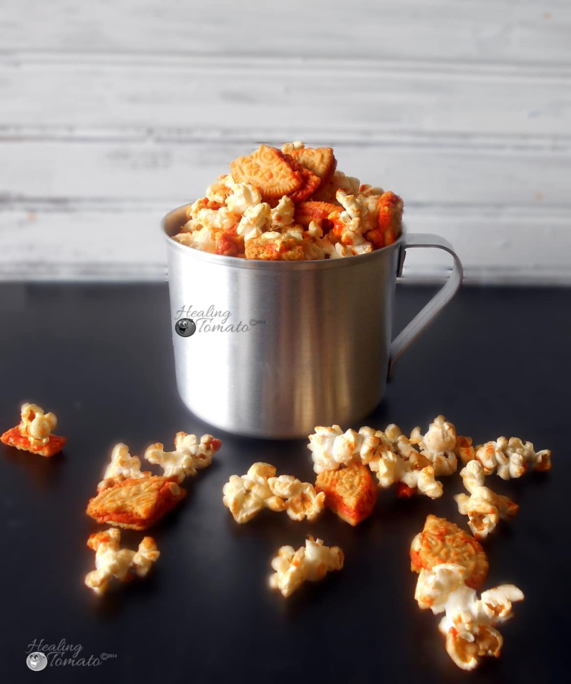 Front view of stainless steel milk container filled to the top with pumpkin spice popcorn