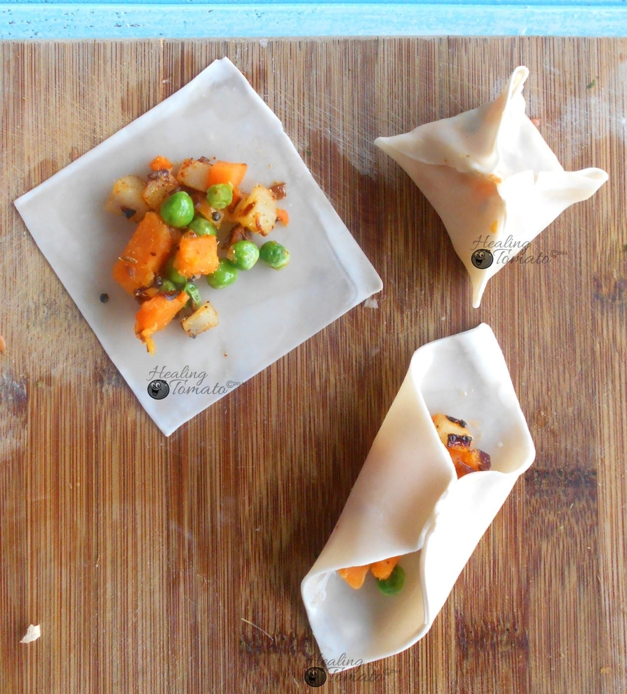 Overhead view of samosa wontons in various stages of being wrapped