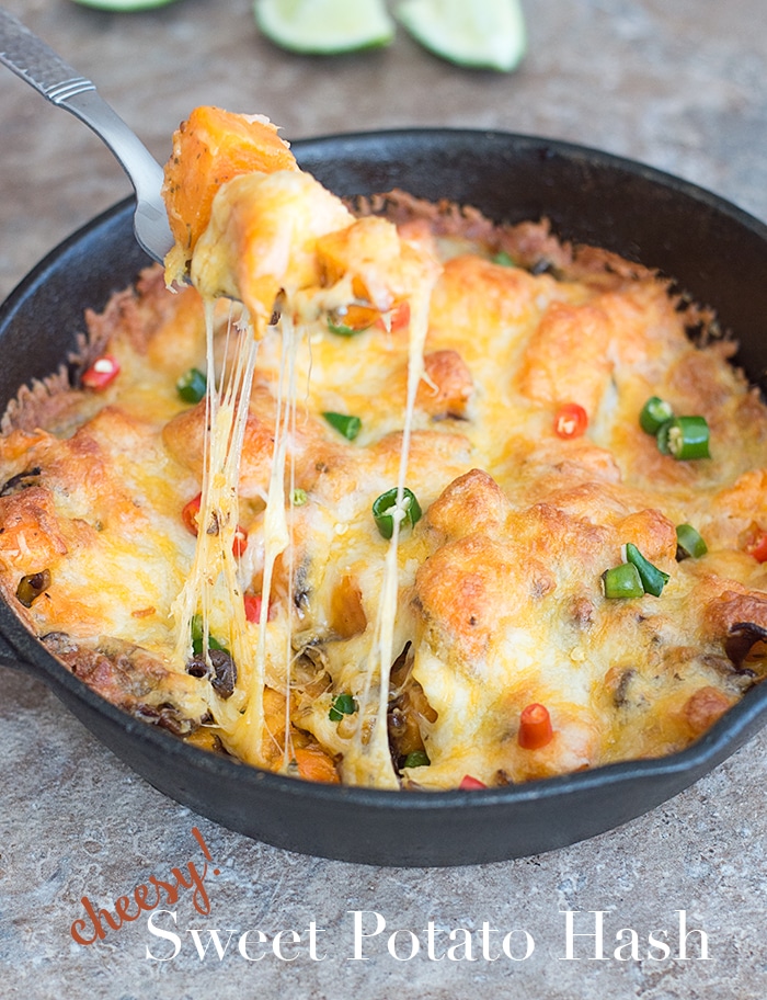 A fork filled with Cheesy Hash Browns on a black cast iron apn