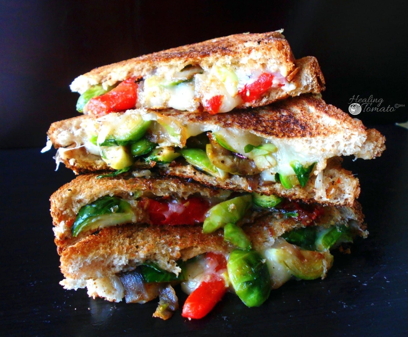 Front view of 4 brussels sprtout grilled cheese sandiwches stacked
