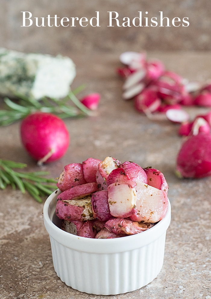 Front View of Buttered Radishes in a Ramekin with Rosemary Sprig and Infused Vegan Butter in the Background