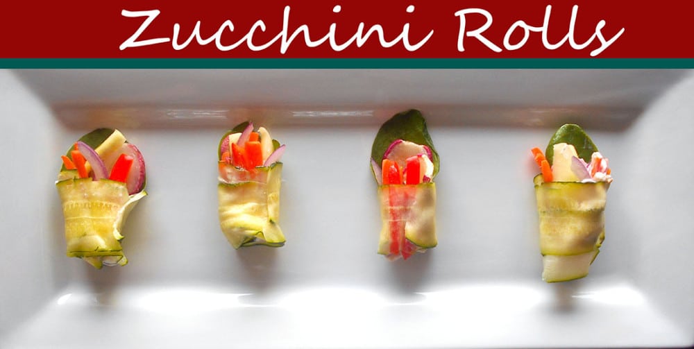 Overhead view of 4 zucchini rolls on a white plate