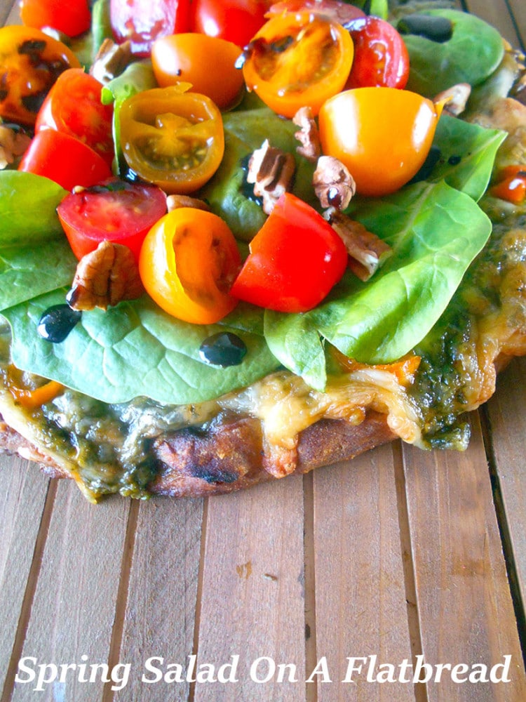 Spring Salad On A Flatbread - Made with baby spinach, cherry tomatoes and pecans. Drizzled with Balasmic Reduction Sauce. Flatbread made with Pesto, mini sweet peppers and cheese https://www.healingtomato.com/2015/04/08/spring-salad-on-flatbread-pizza