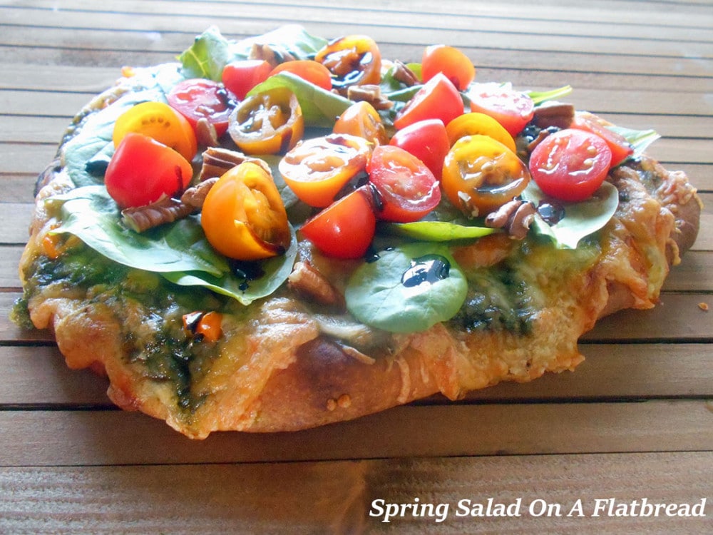 Spring Salad On A Flatbread - Made with baby spinach, cherry tomatoes and pecans. Drizzled with Balasmic Reduction Sauce. Flatbread made with Pesto, mini sweet peppers and cheese https://www.healingtomato.com/2015/04/08/spring-salad-on-flatbread-pizza