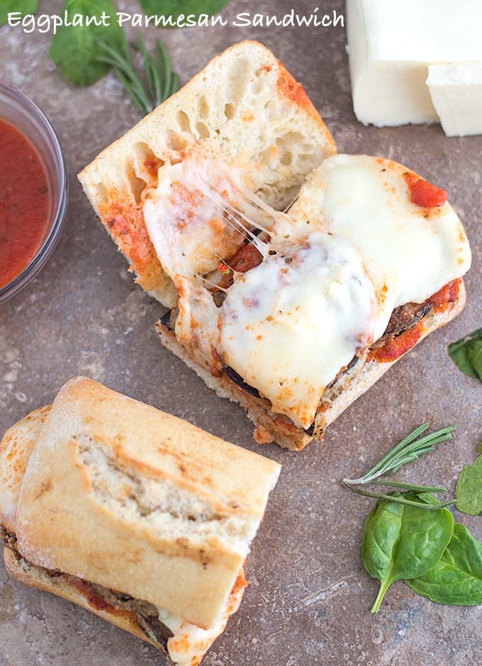 Overhead View of Half of an Open-Faced Eggplant Sandwich with Melted Mozzarella Cheese and Surrounded by a Bowl of Pasta Sauce and Half a Block of Mozzarella Cheese