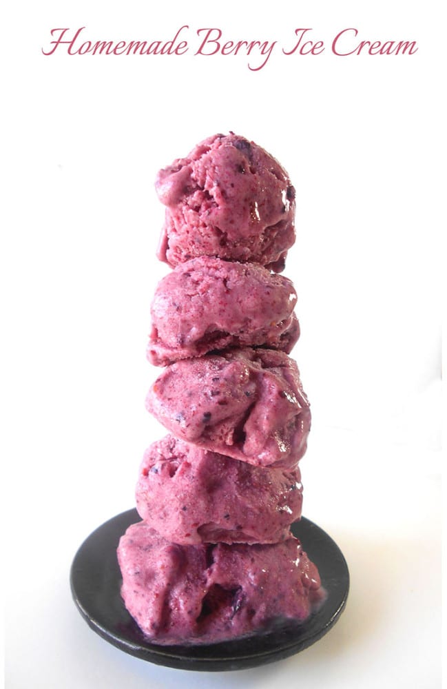 Small balls of berry ice cream stacked on top of each other on a small black plate - homemade ice cream