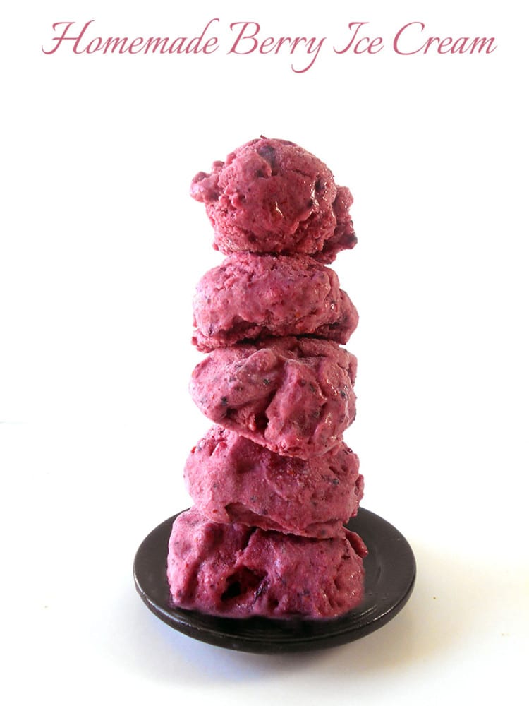 Small balls of berry ice cream stacked on top of each other on a small black plate - homemade ice cream