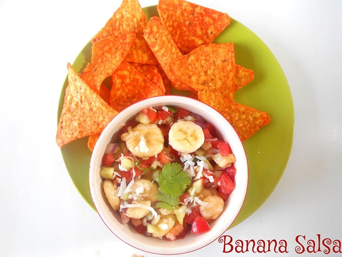 Top View of a Bowl Filled with the salsa on a Green Plate with tortilla chips