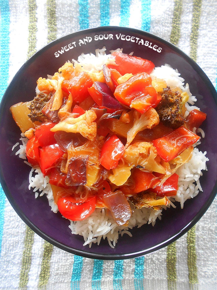 Closeup view of a bowl filled with rice and sweet and sour vegetables 