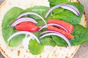 tomatoes and onions topped on the baby kale - vegan gyros