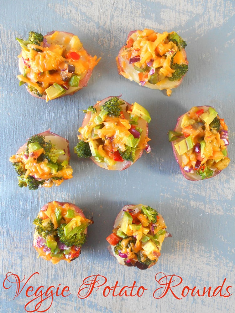 Overhead view of potato rounds loaded with vegetables and topped with cheese
