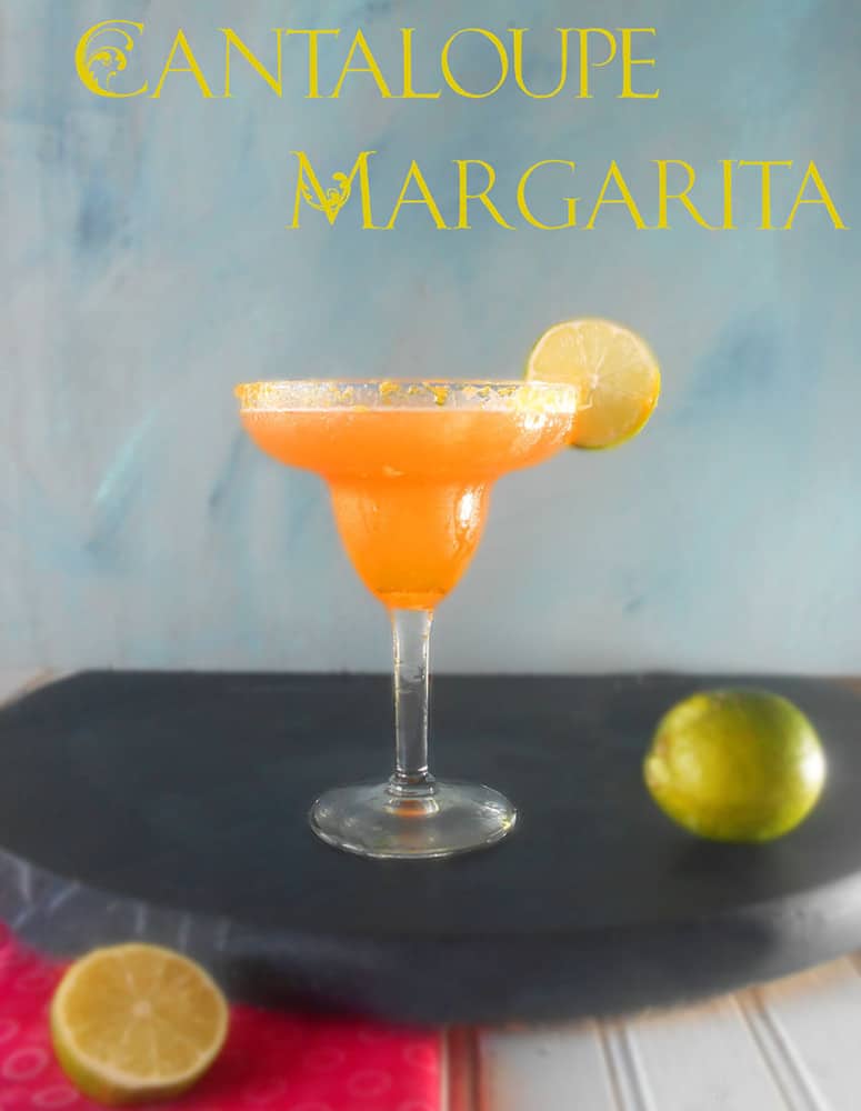 Front view of a margarita glass filled with Cantaloupe Margarita and a garnish of lime. 
