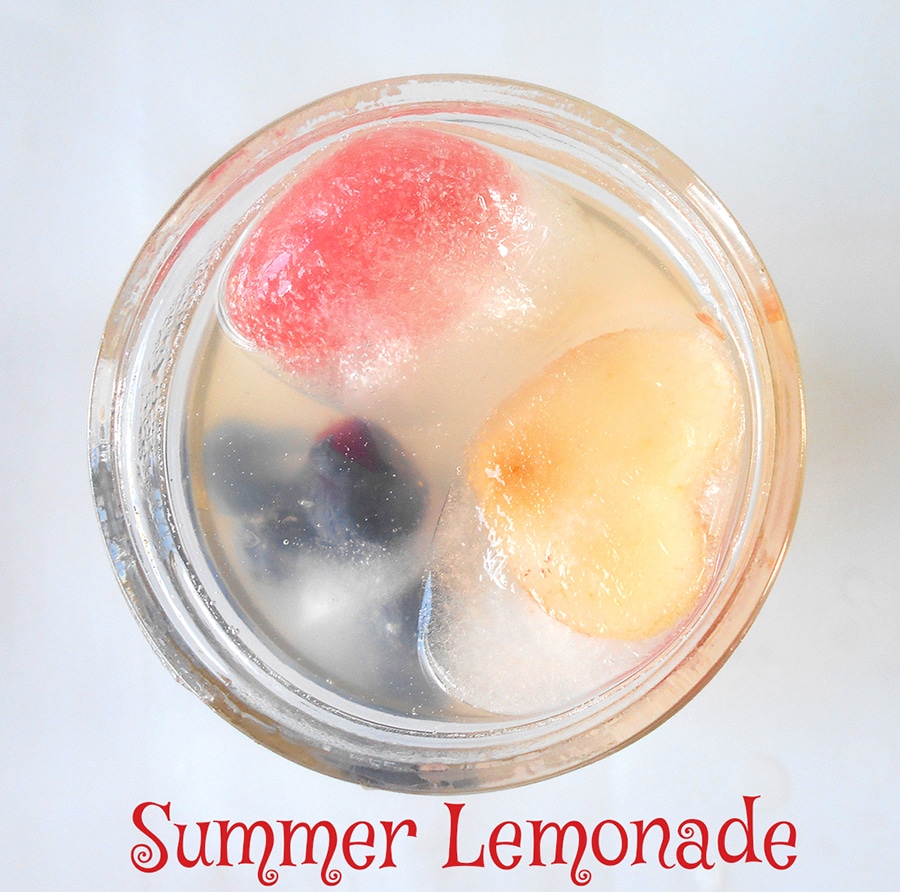 Overhead view of a glass with summer lemonade and fruit ice cubes