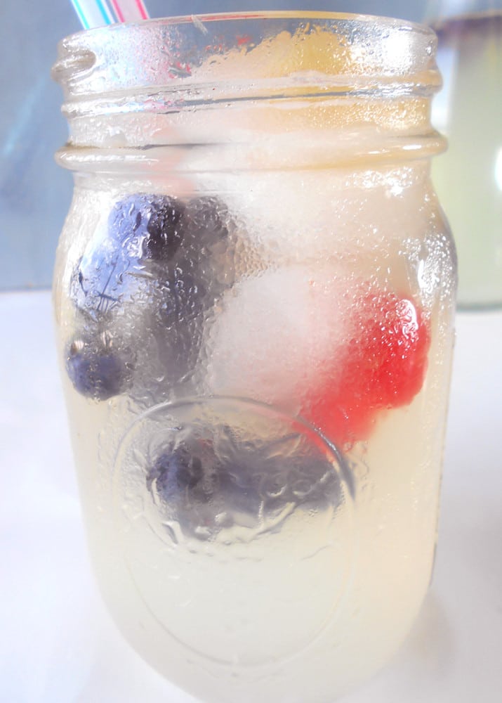 Very closeup view of a glass with summer lemonade and fruit ice cubes
