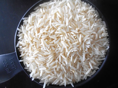 Top view of uncooked basmati rice in a 1 cup measuring cup