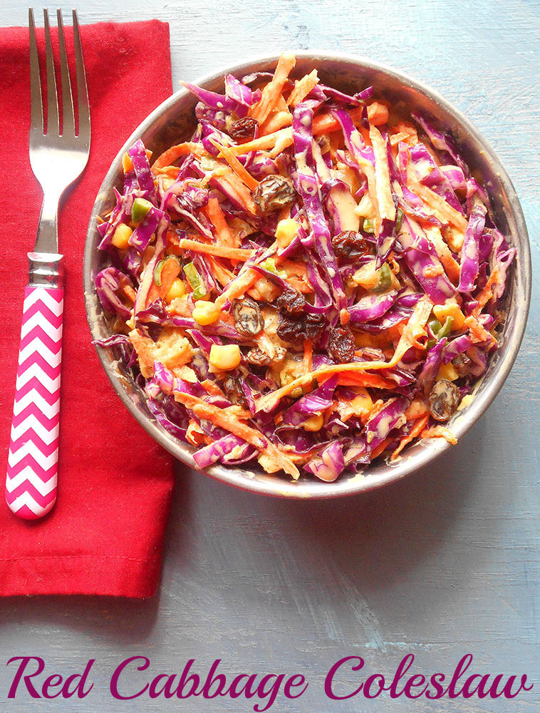 Overhead view of red cabbage coleslaw in a bowl with a red napkin and and fork next to it