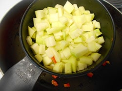 Cubed Zucchini added to a stir fry pan - Vegan Meatloaf recipe