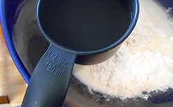 ½ cup measuring cup filled water on a bowl