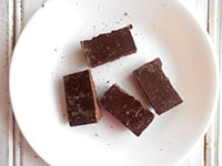 4 squares of chocolate on a white plate - Boozy Hot Chocolate