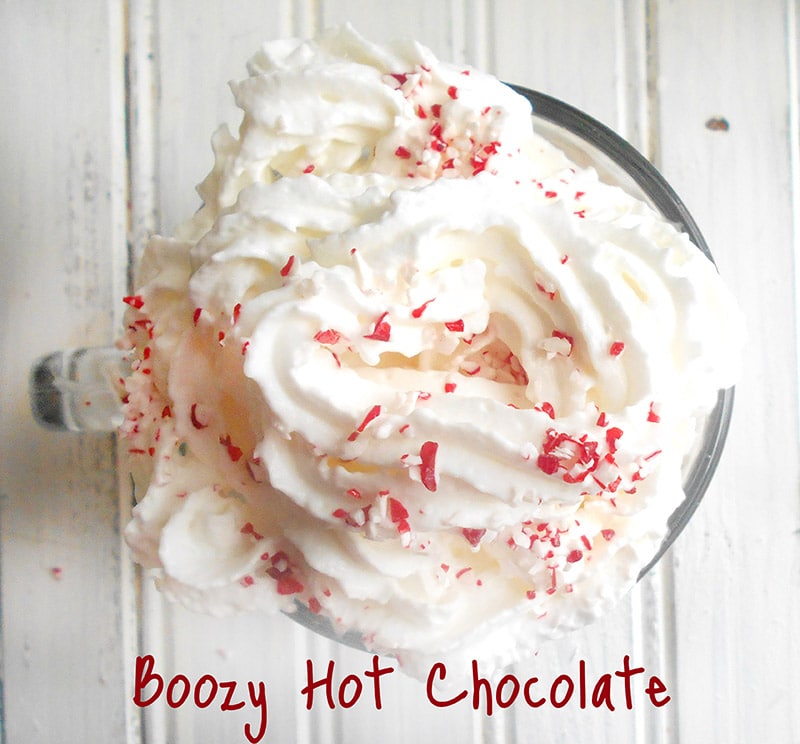 Overhead view of a clear glass with hot chocolate and topped with whipped cream and peppermint bits - Boozy Hot Chocolate