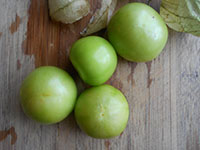 Overhead view of peeled tomatillos on a chopping board