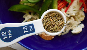 Rosemary being added to the bowl