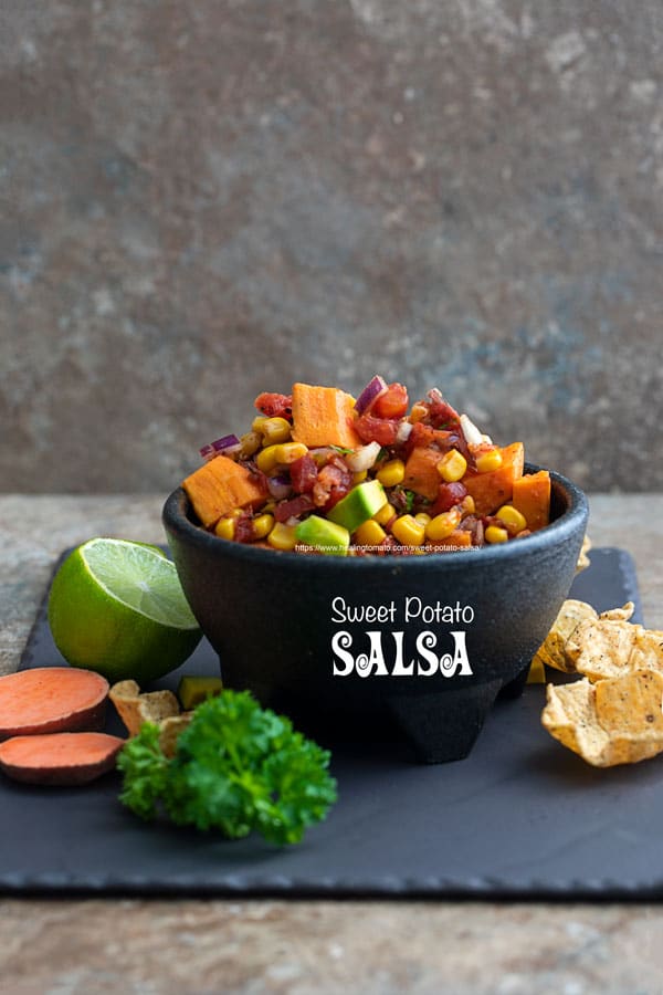 Front view of a black salsa bowl brimming with sweet potato salsa