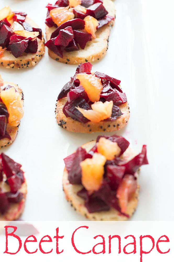 Angle view of bagel chips on a white plate and topped with beetroot and pineapples