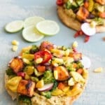 This LOADED vegan tostada is made with salsa marinated tofu, homemade Guacamole and topped with delicious veggies. This is a perfect vegan dinner idea for any weeknight.