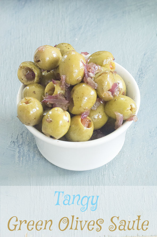 A white ramekin with green olives and cooked red onions - vegan tapas