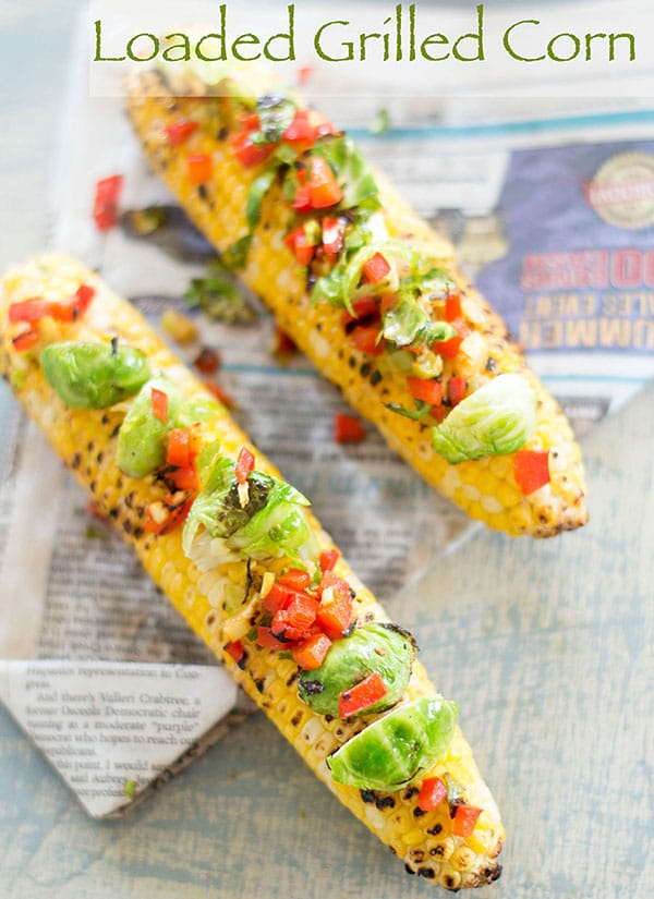 Overhead view of loaded grilled corn on the cob with brussles sprouts and bell pepper