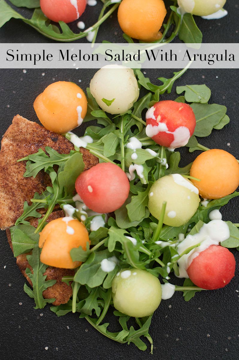 Closeup view of melon balls over arugula and pita bread