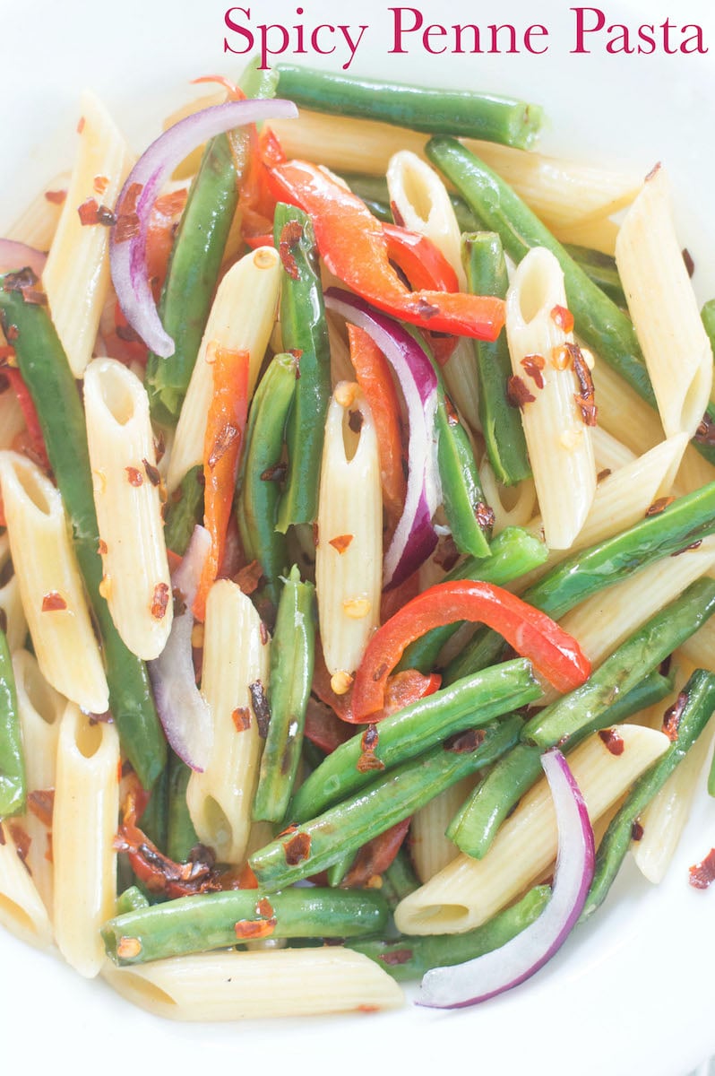 Closeup view of a plate with Penne Pasta, Green Beans, Bell Pepper and Onions