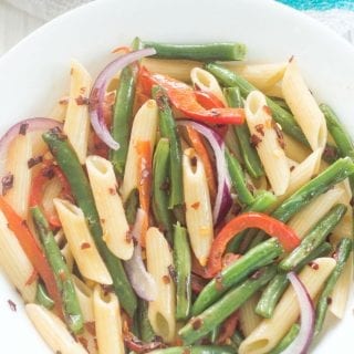 Vegan Spicy Penne Pasta with roasted green beans and red bell peppers. Topped with simple lemon vinaigrette and red pepper flakes. Under 30 minutes to make