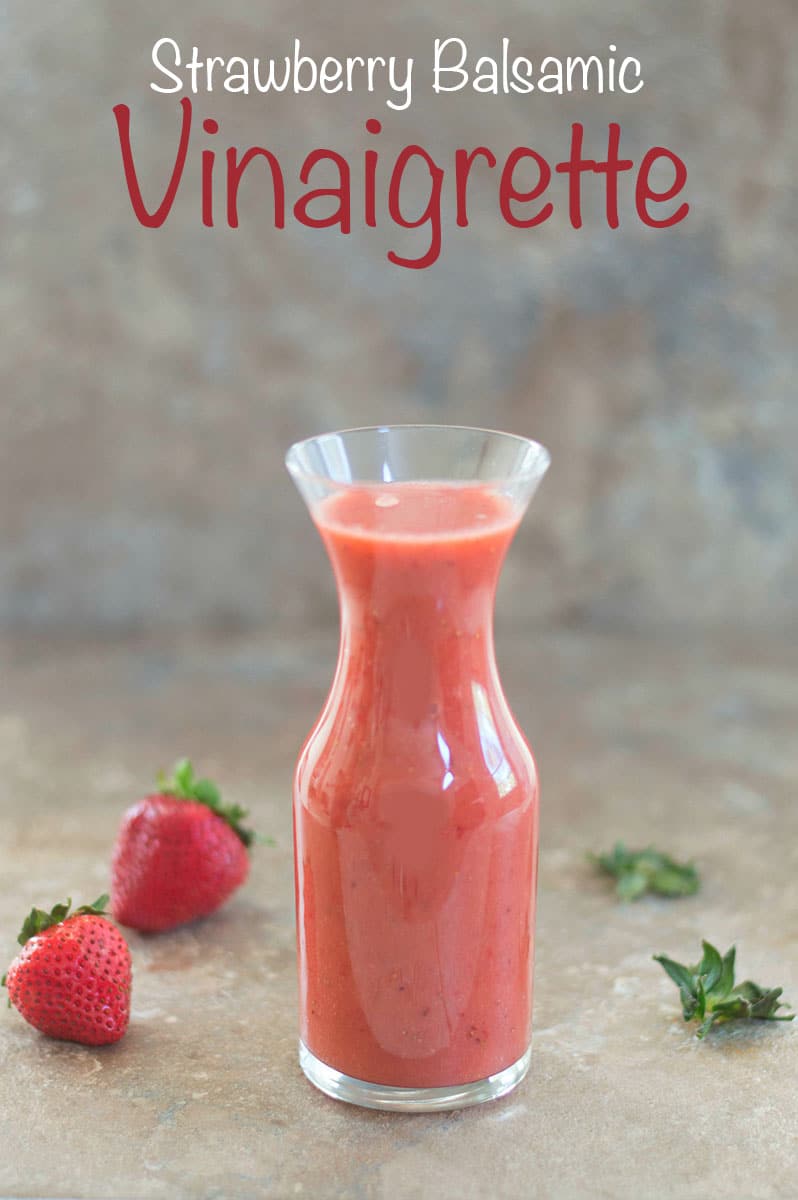 Strawberry Balsamic Vinaigrette in a glass jar with strawberries in the background