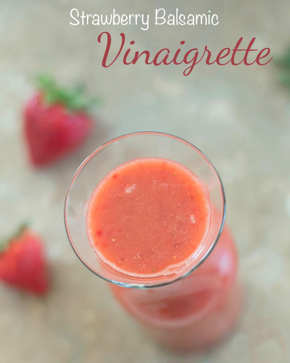 Overhead View of Strawberry Balsamic Vinaigrette in a glass jar with strawberries in the background