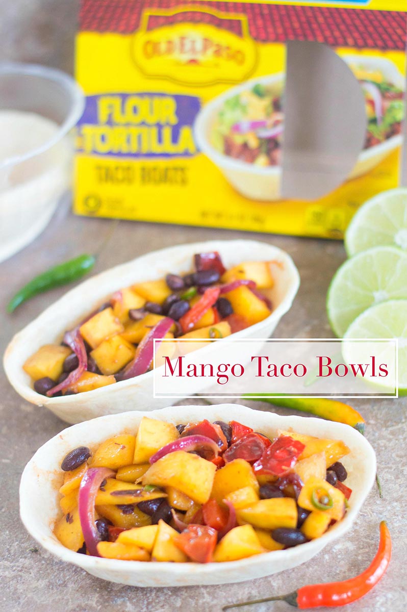 Two taco bowls filled with mango mixture and lime slices + Old El Paso Box in the background