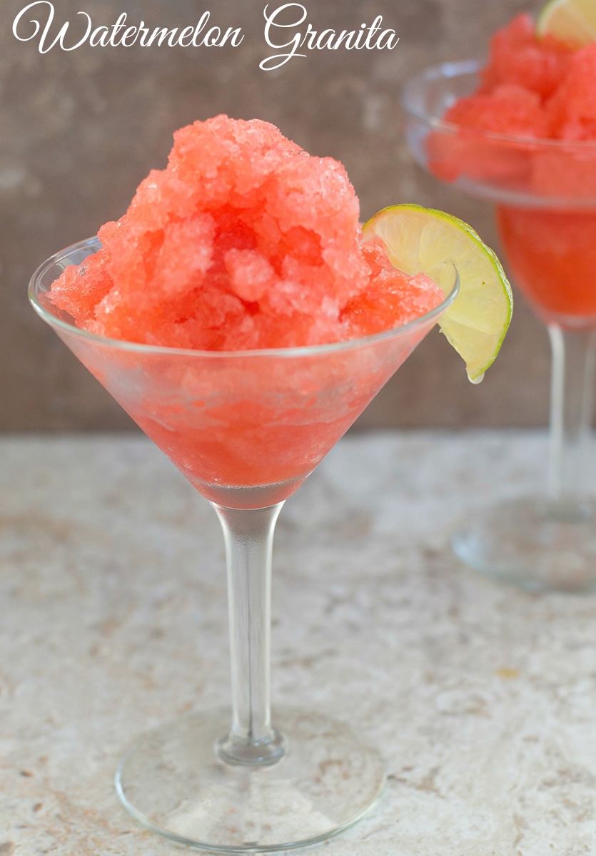 Closeup of two small glass cups with watermelon granita and a wedge of lime