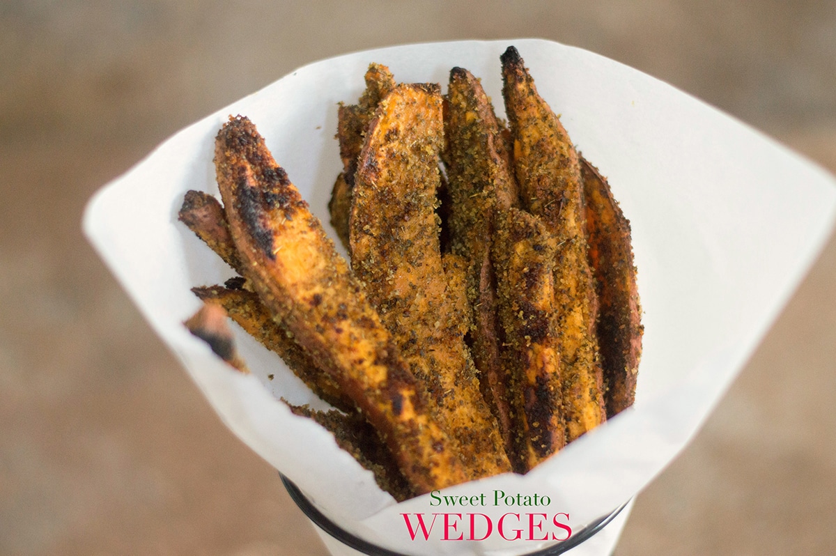 Front View of Sweet Potato Wedges Lined Upright In a Cone Made From Parchment Paper and Placed in a Cone-Shaped Black Fry Holder