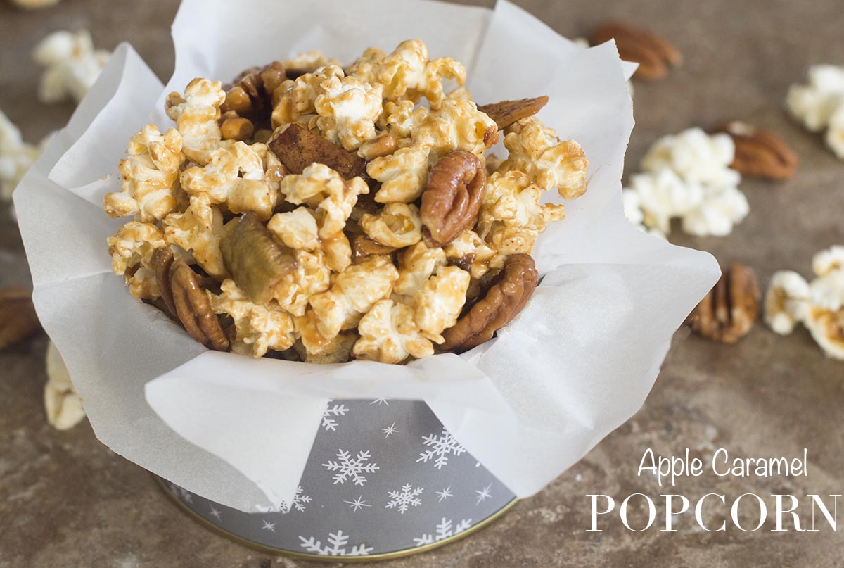 Front view of apple caramel popcorn in holiday container