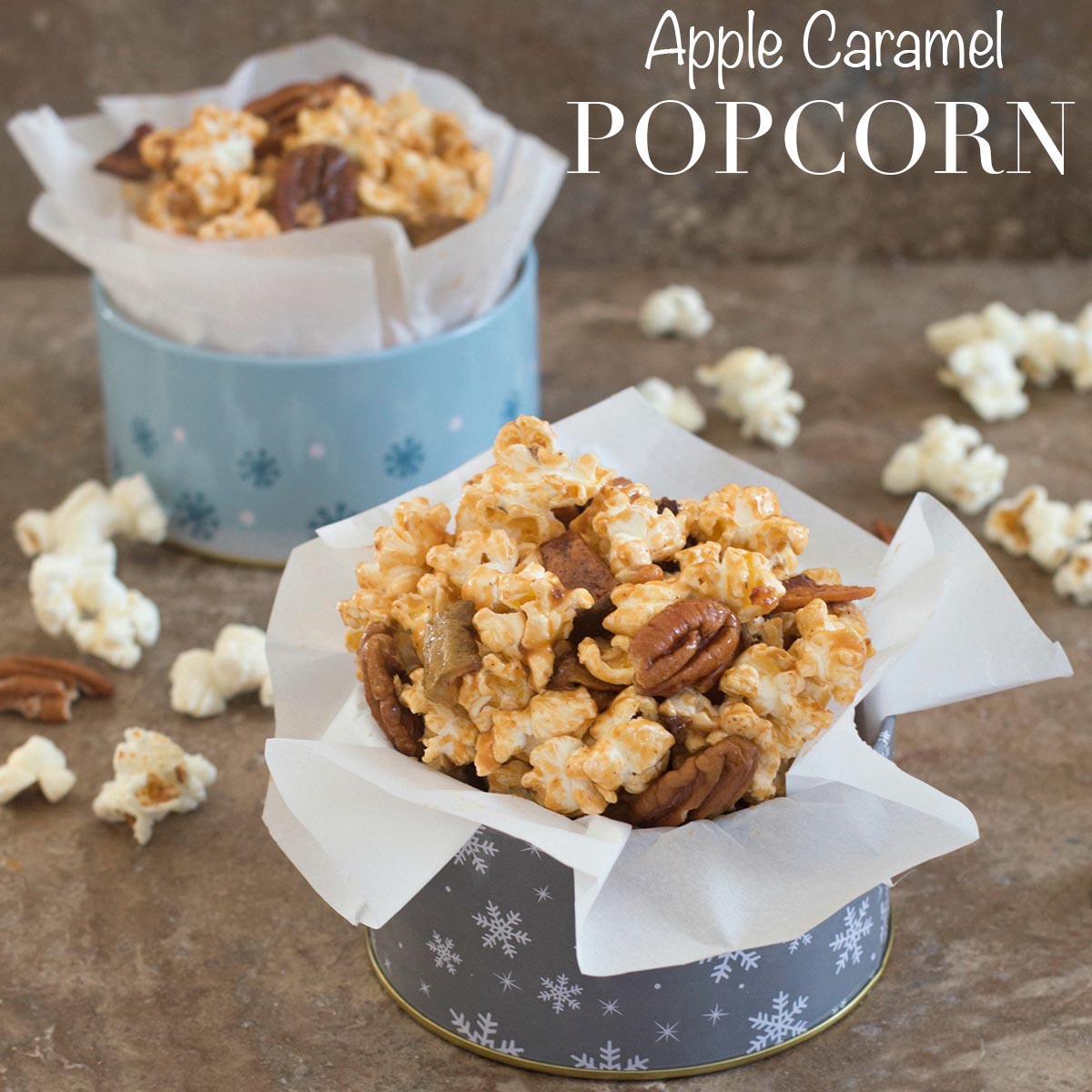 Front view of apple caramel popcorn in holiday containers