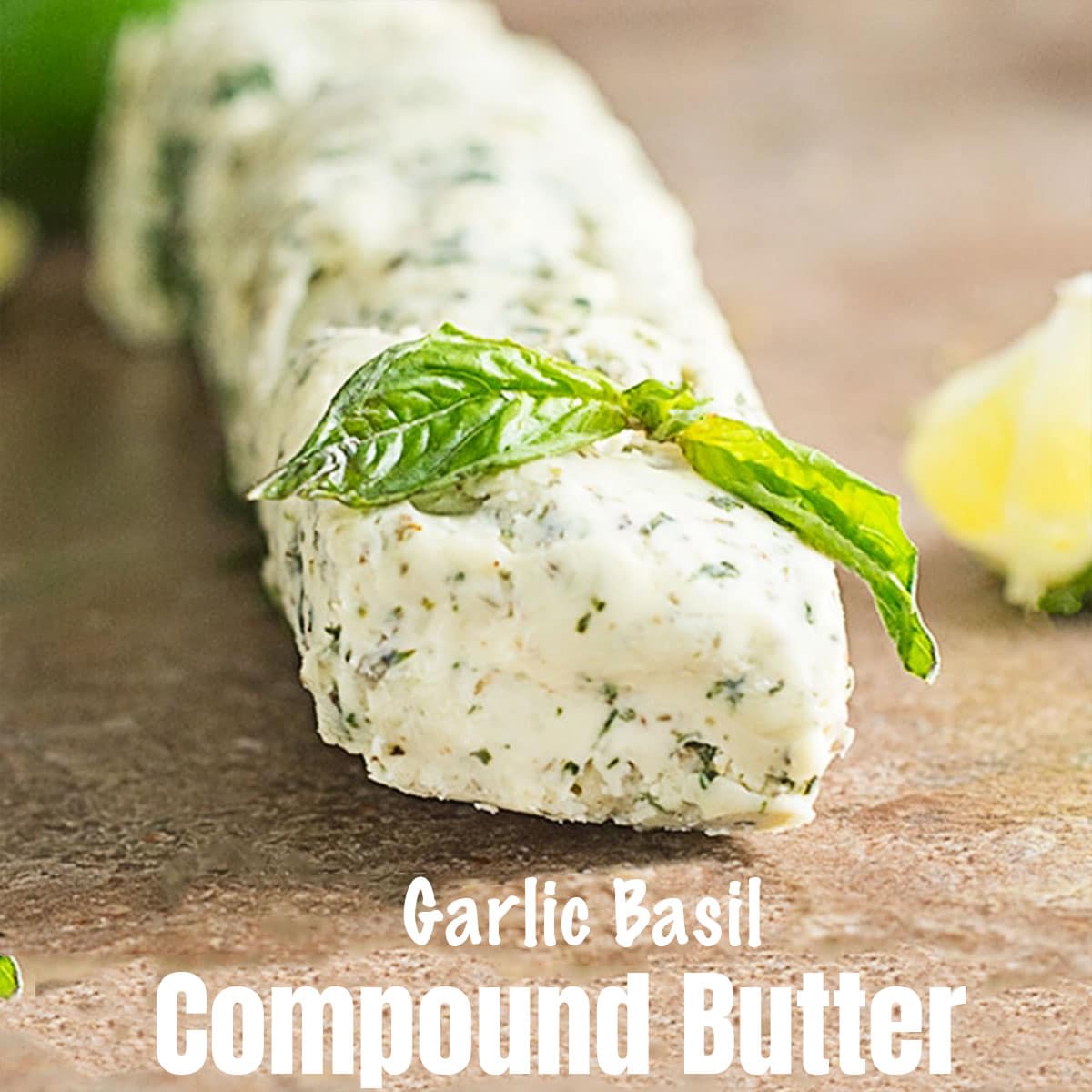 front view of a cylindrical roll of butter with pieces of basil visible.  List of compound butter recipes.